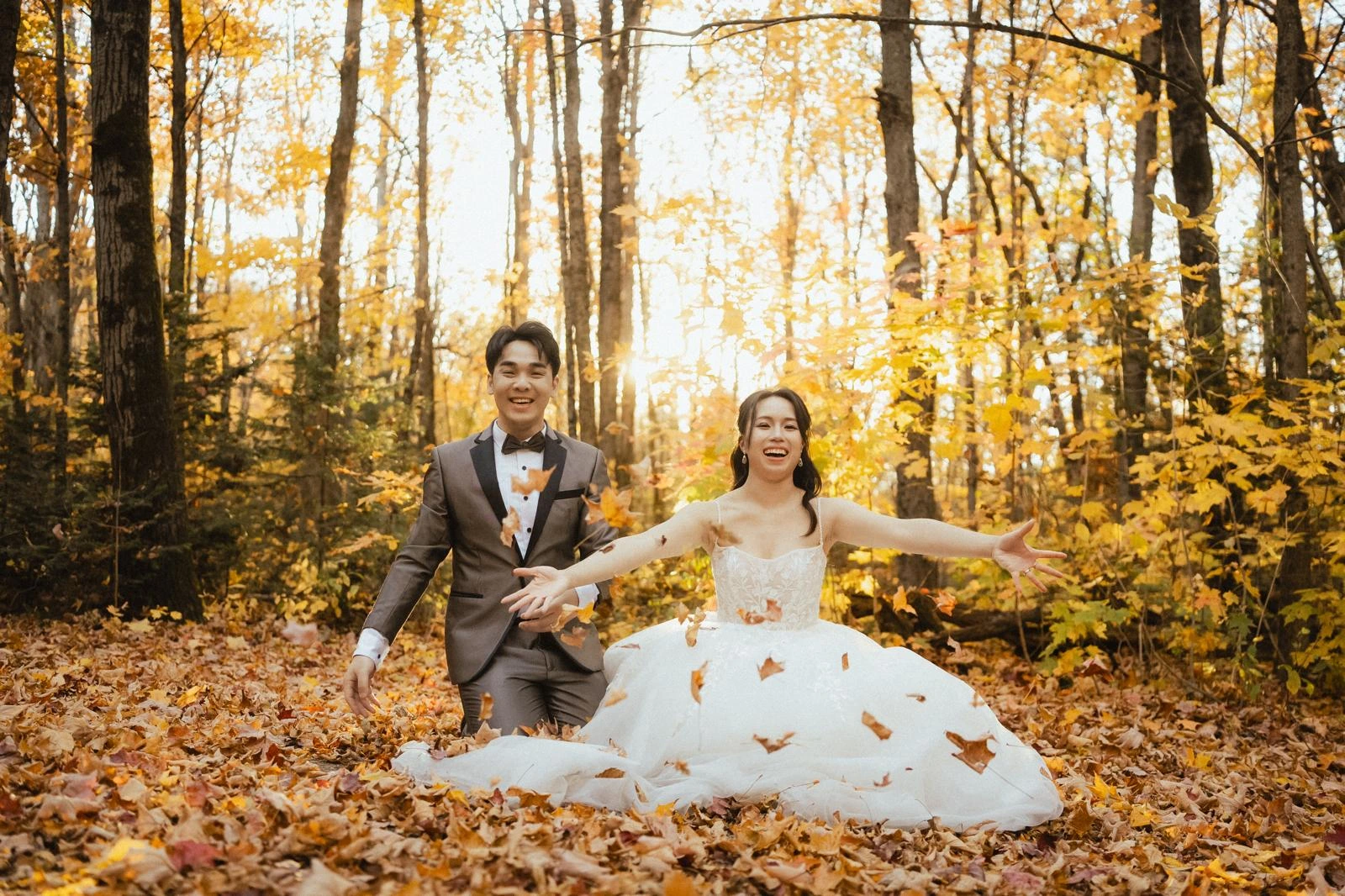 Claudia and Kaming playing with fall leaves